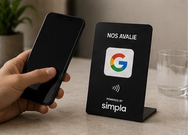 Uma mão aproximando o celular da plaqueta Simpla sobre um balcão de mármore